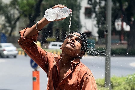 A boy sprays water to get some relief from heat wave on a hot summer afternoon  in New Delhi On Wednesday, May 29, 2024. 