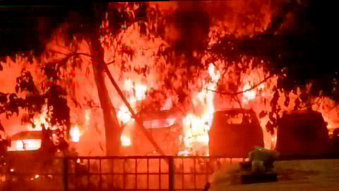 Vehicles engulfed in a fire that broke out at a civic authority-run parking lot in Madhu Vihar area of east Delhi, late Tuesday night, May 28, 2024.