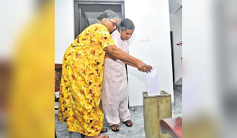 A woman being assisted to cast her vote under the ‘vote from home’ facility in Kottayam 