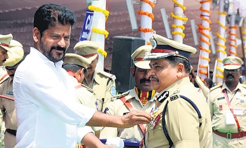 Chief Minister A Revanth Reddy pins a medal on Mahesh Muralidhar Bhagwat, Addl. DGP, Railways and Road Safety, in Hyderabad on Sunday