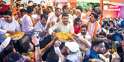 BJP workers distribute sweets to celebrate the party’s victory in the state elections, in Bhubaneswar on Tuesday