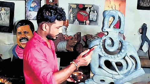 Shibu giving final touches to his Thunchathu Ezhuthachan sculpture