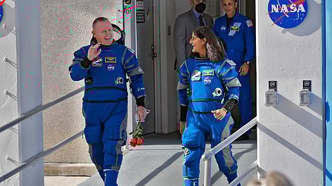 NASA astronauts Butch Wilmore, left, and Suni Williams share a laugh as they leave the operations and checkout building for a trip to launch pad at Space Launch Complex 41 Saturday.