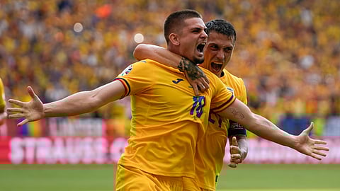 Romania's Razvan Marin, front, celebrates after scoring his side's first goal against Slovakia during a Group E match at the Euro 2024 soccer tournament in Frankfurt, Germany.