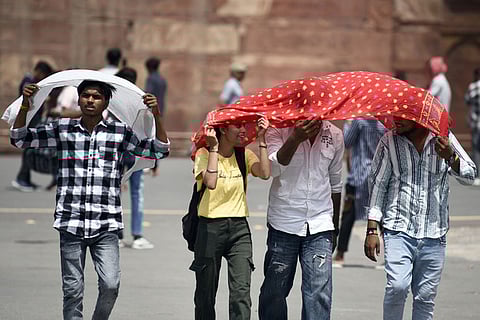 Commuters brave the heat wave during a hot summer afternoon, in Delhi, on June 18, 2024.