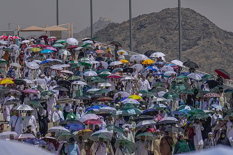 Muslim pilgrims use umbrellas to shield themselves from the sun as they arrive to cast stones at pillars in the symbolic stoning of the devil, the last rite of the annual hajj, in Mina, near the holy city of Mecca, Saudi Arabia, Tuesday, June 18, 2024