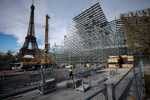 Workers build the stands for the upcoming Olympic Games on the Champ-de-Mars just beside the Eiffel Tower, in Paris, April 1, 2024 in Paris