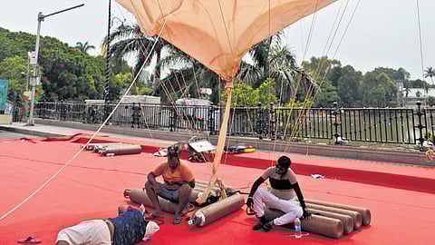 Workers rest under an air balloon during the day in Hyderabad 