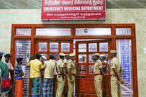 Police personnel and others stand outside the emergency medicine department at a government hospital where patients are being treated after consuming spurious liquor, in Kallakurichi, Friday, June 21, 2024.