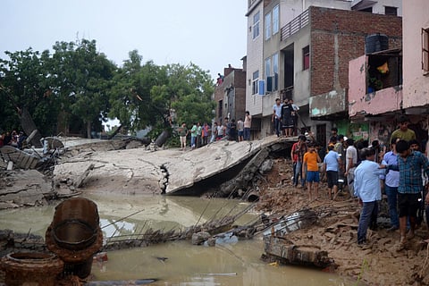 People near the debris after a water tank collapsed due to heavy rainfall, in Mathura, Sunday, June 30, 2024. 