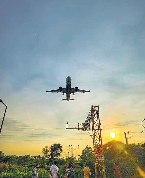 People gather at Kallumkoottam viewpoint in Kochi to watch a flight landing 
