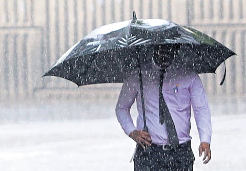 A man covers himself with an umbrella as rains lash Begumpet on Tuesday. The IMD has issued a yellow alert for rain in the city till June 8 