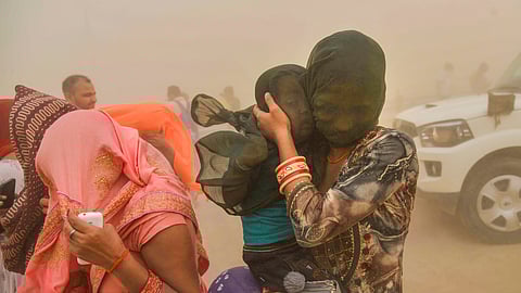 A family tries to take cover during a dust storm, in Patna, Monday, June 3, 2024.