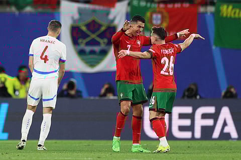 Portugal's forward #07 Cristiano Ronaldo and Francisco Conceicao celebrate on the pitch after the UEFA Euro 2024 Group F football match between Portugal and the Czech Republic on June 18, 2024. 
