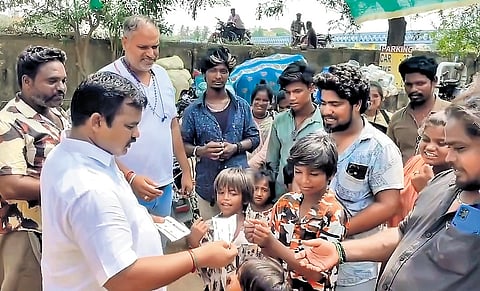 Cuddalore Tahsiladar A Balaraman handing over tickets to a matinee show of ‘Garudan’ to members of the Narikuravar community on Saturday 