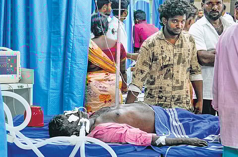 Family members stand next to patients admitted to Kallakurichi GH on Friday