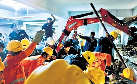 Rescue teams pull a labourer from under the debris of a collapsed wall
