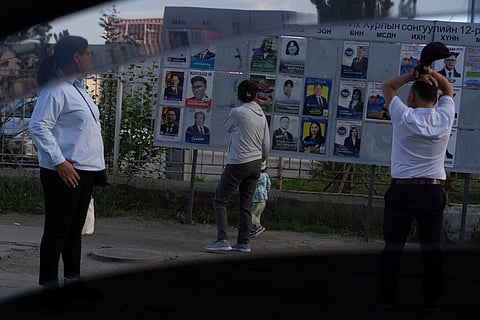 Residents look at election posters of candidates