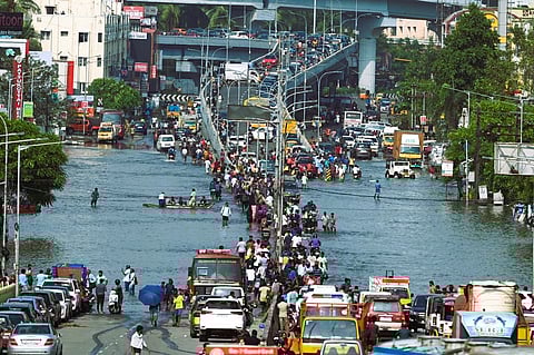 Commuters wade across Velachery after heavy rains ahead of Cyclone Michaungs landfall in Chennai.