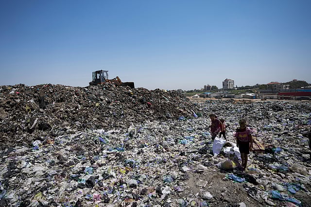 Palestinians sort through trash at a landfill in Nuseirat refugee camp, Gaza Strip.