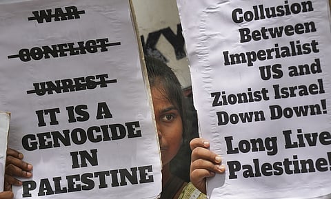 People hold placards during a protest organised by Palestine Solidarity Committee in support of Palestinians amid the ongoing genocidal war in Gaza. 