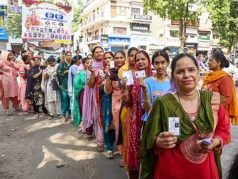 Voters display their identity cards while standing in a queue to cast their votes at a polling booth during the seventh phase of the Lok Sabha elections in Chandigarh (Photo | PTI) 