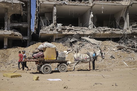 Palestinians salvage items from the destruction in the wake of an Israeli air and ground offensive in Jebaliya, northern Gaza Strip, after Israeli forces withdrew from the area, Friday, May 31, 2024.