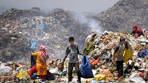 Waste picker Rajdin, 17, looks for recyclable material during a heat wave at a garbage dump on the outskirts of Jammu, Wednesday, June 19, 2024.