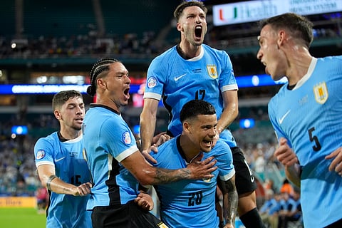Uruguay's Maximiliano Araujo, bottom center celebrates with teammates after scoring his side's opening goal against Panama during Copa America 