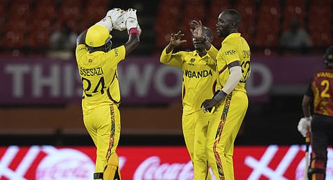 Uganda's captain Brian Masaba, center, celebrates with teammates Robinson Obuya and Simon Ssesazi after taking the wicket of Papua New Guinea's Chad Soper during an ICC Men's T20 World Cup cricket match at Guyana National Stadium in Providence, Guyana, Wednesday, June 5, 2024. 