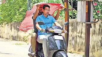 Bikers protect themselves from the sun with a towel in Bhubaneswar | 
