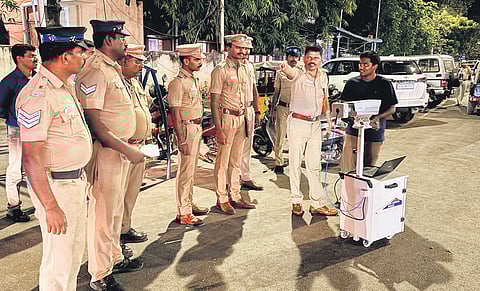 Policemen inspecting a portable tripod camera at a vehicle checkpoint