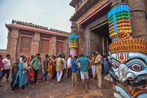 Devotees enter and leave through a gate of the Jagannath Temple after Odisha government opened all four doors for the public in Puri on Thursday.