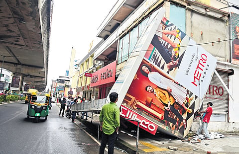 Workers trying to clear the billboard on MG Road that collapsed following the strong wind and heavy rain that lashed the city in the early hours of Friday 