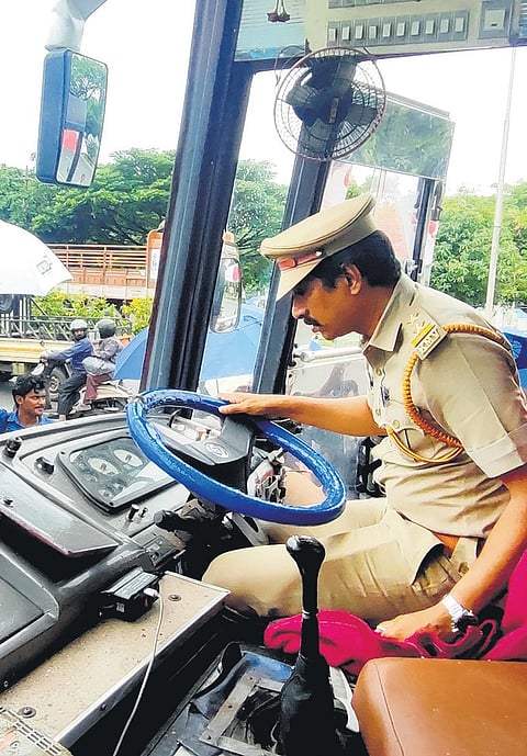 Motor vehicle officials inspect the inside of the stricken bus after it is lifted by a crane at Madavana in Kochi on Sunday