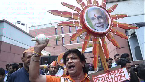 BJP workers celebrate the partys lead in the Lok Sabha elections amid the counting of votes, near the party headquarters, in New Delhi.