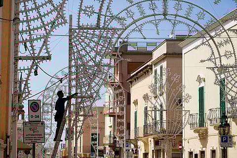 Workers give last touch to the illumination set in view of the Patron saint feast in Fasano, near Borgo Egnazia, southern Italy, Wednesday, June 12, 2024.
