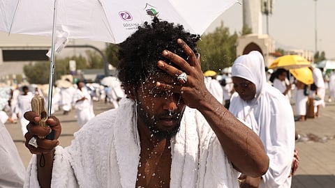 A Muslim pilgrim splashes water on his head to cools off at the base of Saudi Arabia's Mount Arafat, also known as Jabal al-Rahma or Mount of Mercy, during the climax of the Hajj pilgrimage on June 15, 2024