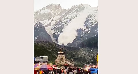 Snow comes down a cliff during an avalanche after a glacier broke down as devotees offer prayers at Kedarnath dham, in Rudraprayag district, Sunday, June 30, 2024.