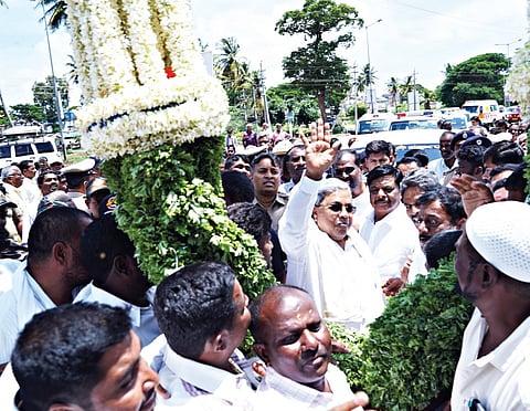 Chief Minister Siddaramaiah waves at supporters in Chamarajanagar on Wednesday.