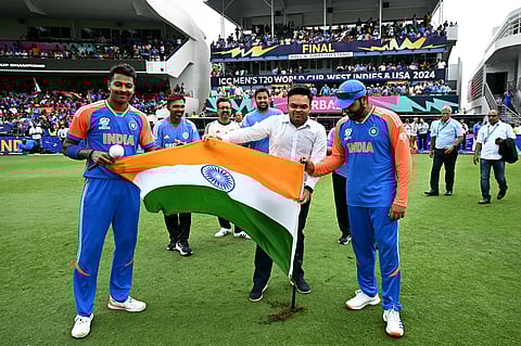 Jay Shah (C), Secretary of the BCCI, holds the flag of India with India's Hardik Pandya (L) and captain Rohit Sharma (R) after India won the ICC men's Twenty20 World Cup 2024 final cricket match between India and South Africa on June 29, 2024.