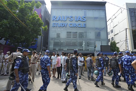Security personnel stand guard near a UPSC exam coaching centre after three civil services aspirants died when the basement of the coaching centre was flooded following heavy rain, in New Delhi, Sunday, July 28, 2024.