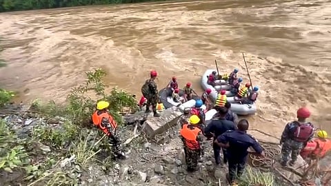 Nepali Army troops and others during a rescue operation after buses were swept away by a landslide, in Chitwan district.