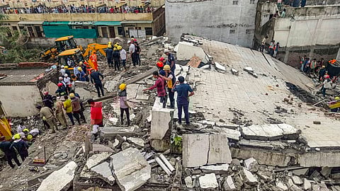 Officials and others during a rescue operation after a building collapse, in Surat district, Saturday, July 6, 2024.