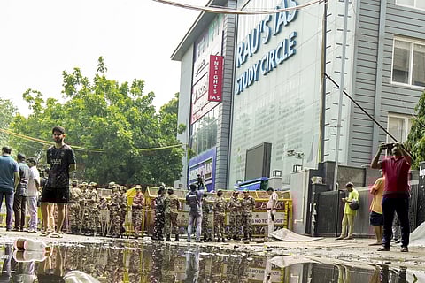 Security personnel stand guard near a UPSC exam coaching centre after three civil services aspirants died when the basement of the coaching centre was flooded by rainwater, in New Delhi, Sunday, July 28, 2024. 