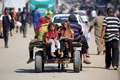 Displaced Palestinians ride in the back of a donkey-drawn cart in Deir el-Balah in the central Gaza Strip on July 22, 2024.