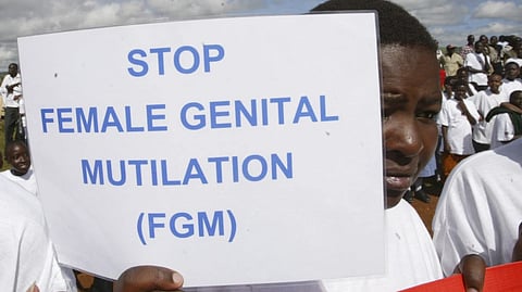 A Masai girl holds a protest sign during the anti-Female Genital Mutilation (FGM) run in Kilgoris, Kenya, on April 21, 2007.