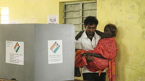 A senior citizen being carried to a polling booth at Panayapuram.