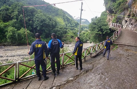 SDRF personnel inspect after the Yamuna river breached its embankment due to heavy rainfall, at Janki Chatti area in Uttarkashi