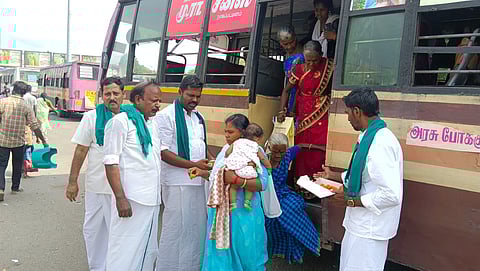 Farmers celebrating the release of River Cauvery water by distributing sweets to the public near New Bus Stand in Nagapattinam on Sunday